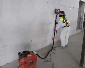 skilled worker grinding concrete wall